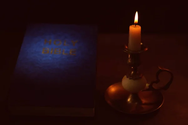 Библия и горящая свеча — стоковое фото