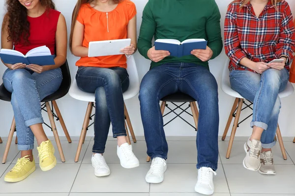 Grupo Personas Con Libros Aparatos Sentados Cerca Pared Luz — Foto de Stock