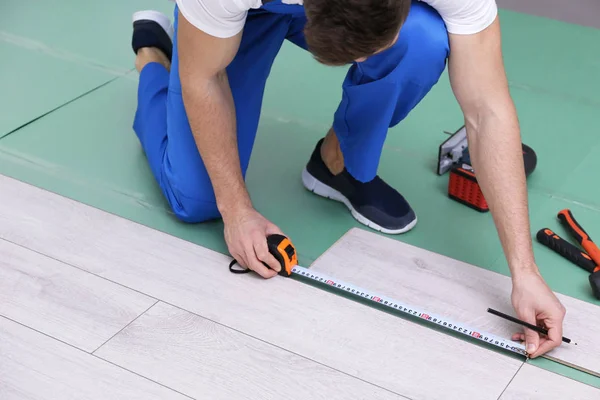 Man installing new wooden laminate flooring — Stock Image Man installing new wooden laminate flooring Royalty Free Stock Images