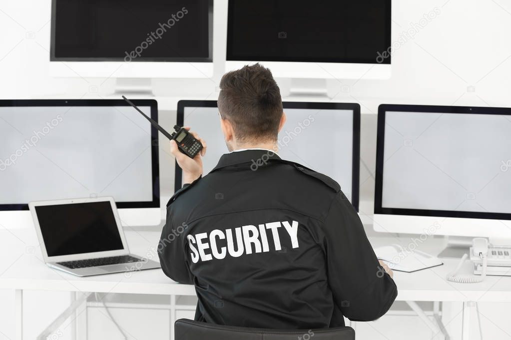 Handsome security guard in surveillance room