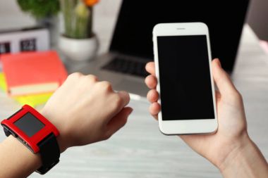 Kalp atış hızı monitörünü izle ve smartphone tablo arka plan üzerinde tutan eller