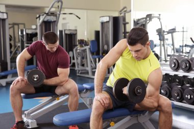 Spor salonunda eğitim dumbbells ile genç yakışıklı erkekler