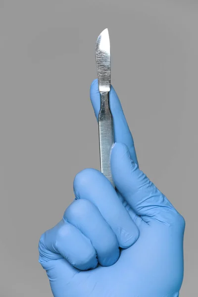 Hand of doctor with lancet on grey background — Stock Photo, Image