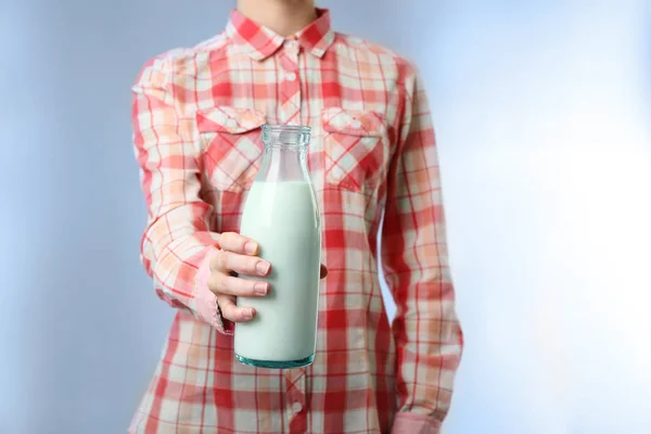 Kvinna anläggning flaska mjölk — Stockfoto