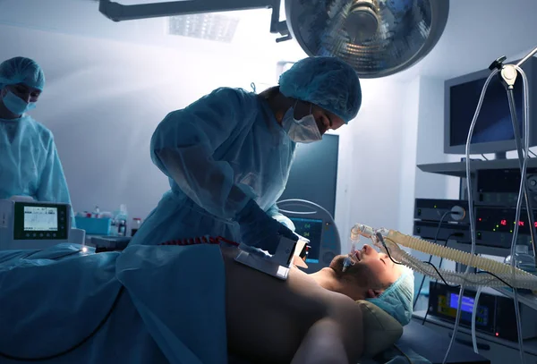 Doctor trying to save patient's life in clinic — Stock Photo, Image