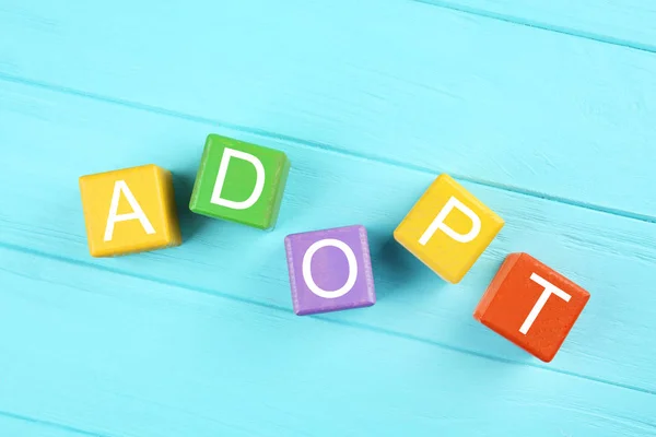 Färgglada kuber med ordet Adopt — Stockfoto