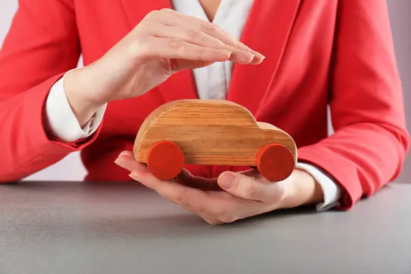 Main féminine et voiture jouet en bois — Photo