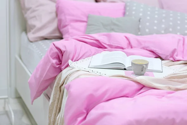 Taza de café y libro en la cama — Foto de Stock