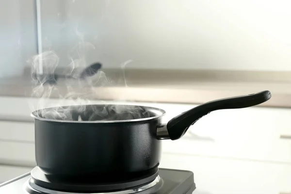 Metal saucepan on stove — Stock Photo, Image