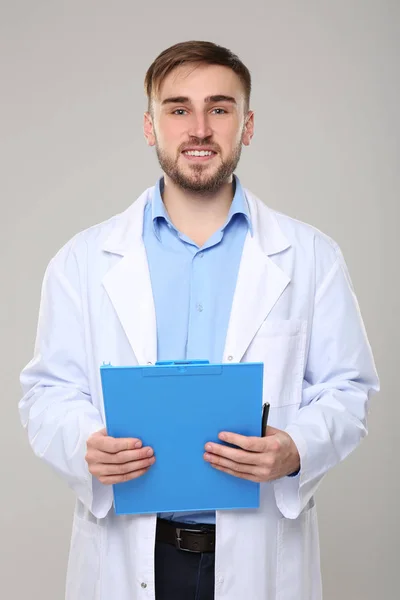 Dokter tampan dengan papan klip biru — Stok Foto
