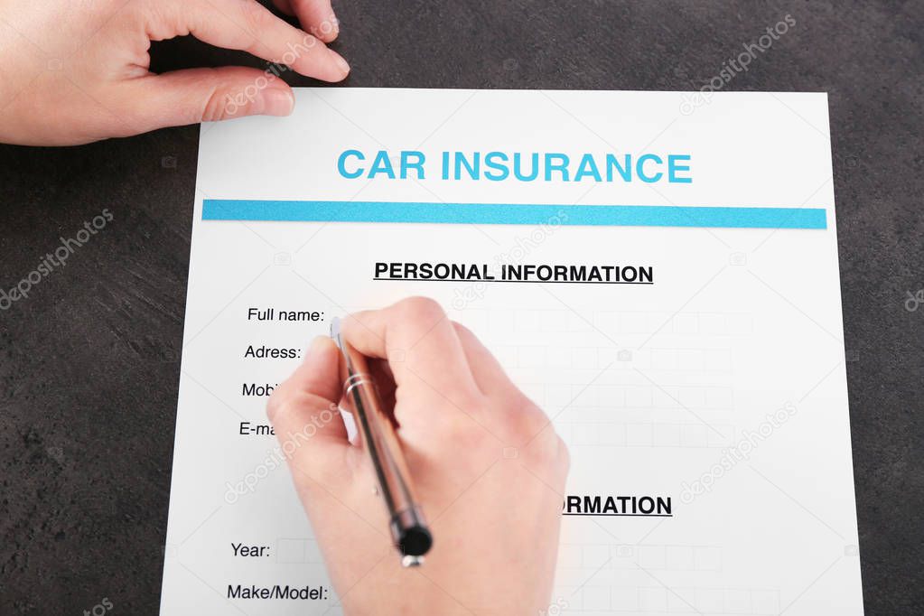Hand filling in car insurance form  