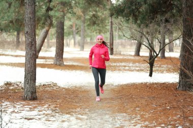 Kadın parkta koşuyor.