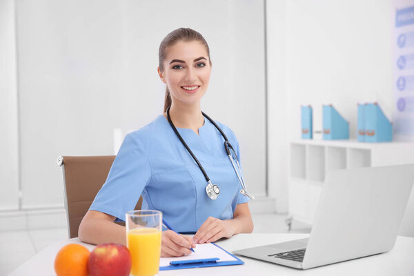 Молодая женщина-диетолог в своем офисе
