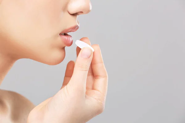 Hermosa Mujer Tomando Píldora Sobre Fondo Claro — Foto de Stock