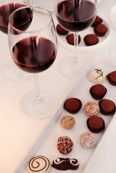 Deliciosos chocolates y copas de vino —  Fotos de Stock