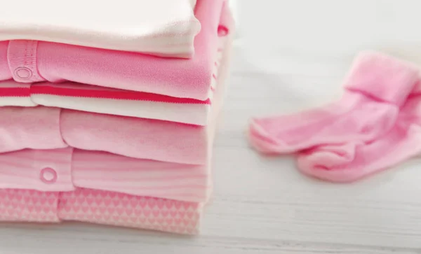 Pilha de roupas de bebê e meias — Fotografia de Stock