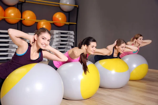 Jovens mulheres esportivas treinando com bolas de fitness no ginásio — Fotografia de Stock