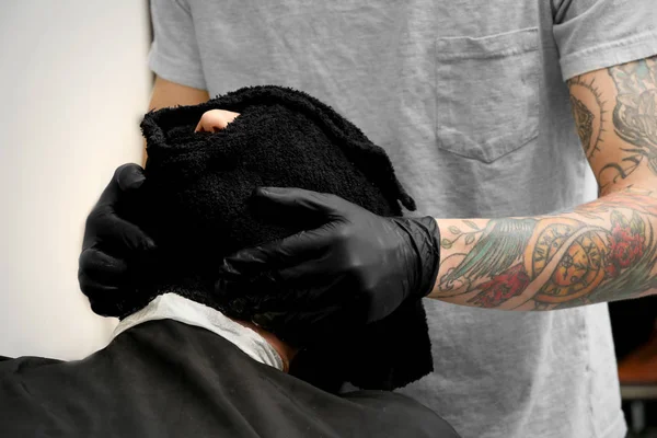 Čištění obličeje klienta s ručníkem v holičství kadeřnictví — Stock fotografie