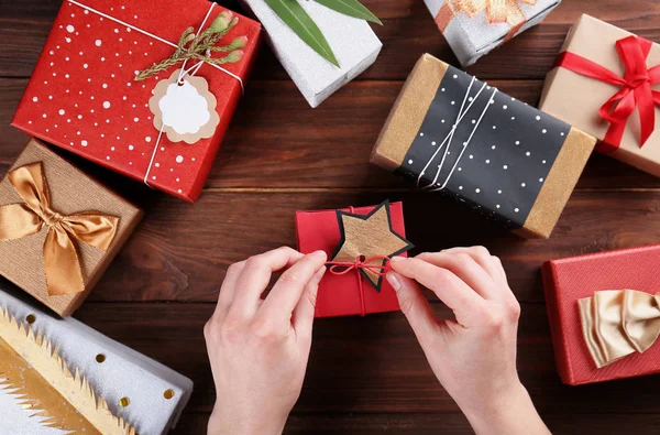 Female hands decorating gifts — Stock Photo, Image