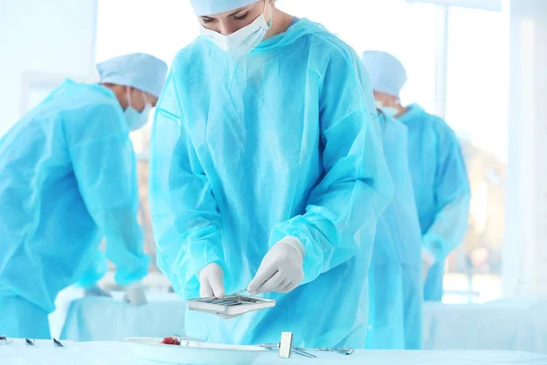 Médico tomando instrumentos para operação cirúrgica na clínica — Fotografia de Stock