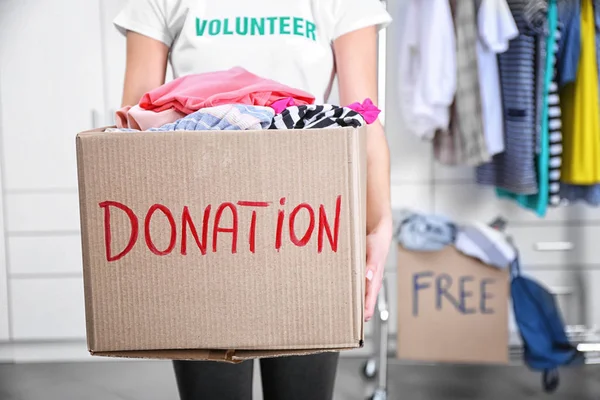 Волонтер в коробке для пожертвований — стоковое фото