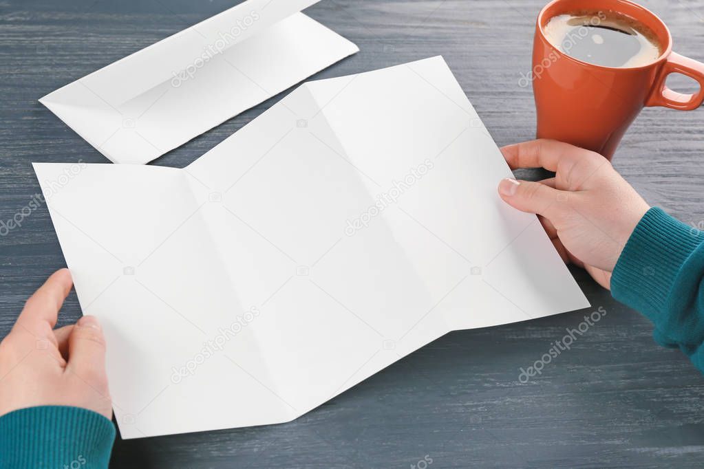 Female hands holding blank brochure 