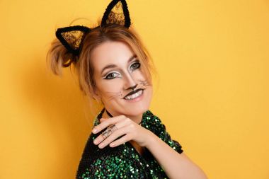 Beautiful young woman with cat makeup and ears on color background clipart