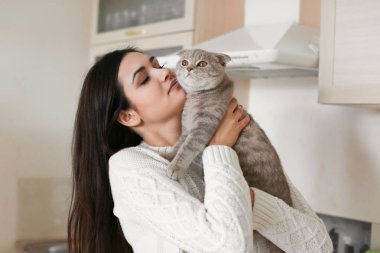 Şirin kedisi olan güzel genç bir kadın.  