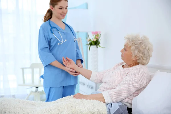 Female doctor taking care about elderly patient — Stock Photo, Image