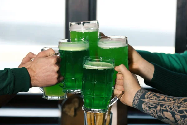 Hands of people with beer celebrating Saint Patrick\'s Day in pub