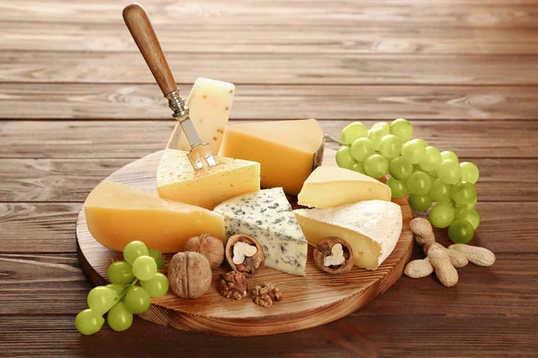 Tafel mit verschiedenen Käsesorten auf Holzgrund — Stockfoto
