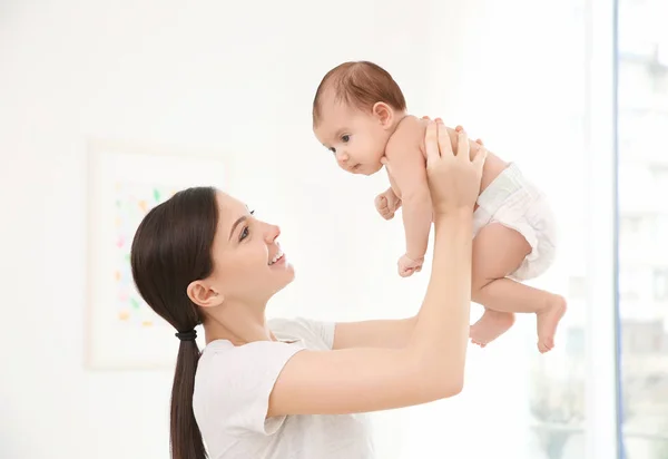 Mãe feliz com bebê pequeno bonito em casa — Fotografia de Stock