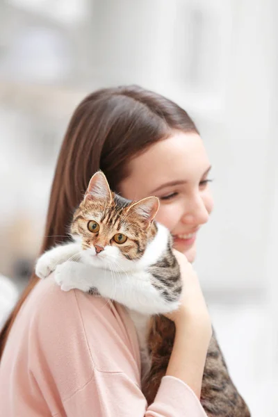 Piękna młoda kobieta z uroczym kotem w domu — Zdjęcie stockowe