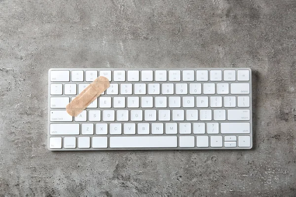 Laptop tangentbord med självhäftande bandage — Stockfoto