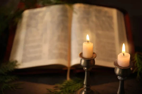 burning candles with open Bible
