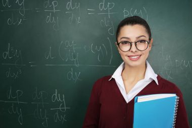 Güzel genç öğretmen sınıfta blackboard yakınındaki