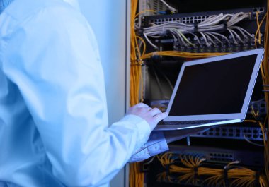 Sunucu odası içinde laptop ile yakışıklı genç mühendis
