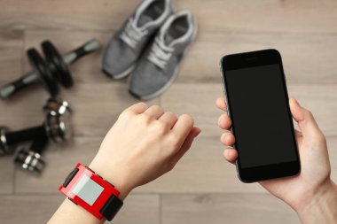 Kalp hızı monitörü izlemek ve smartphone, closeup ile eller