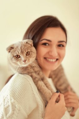 Şirin kedisi olan güzel genç bir kadın.  