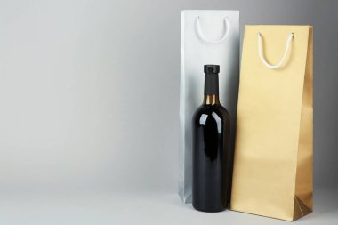 Gri arka plan üzerinde şarap şişe ve Hediyelik çanta