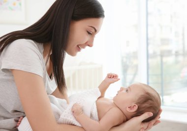 Mutlu anne ve evde küçük şirin bir bebek.