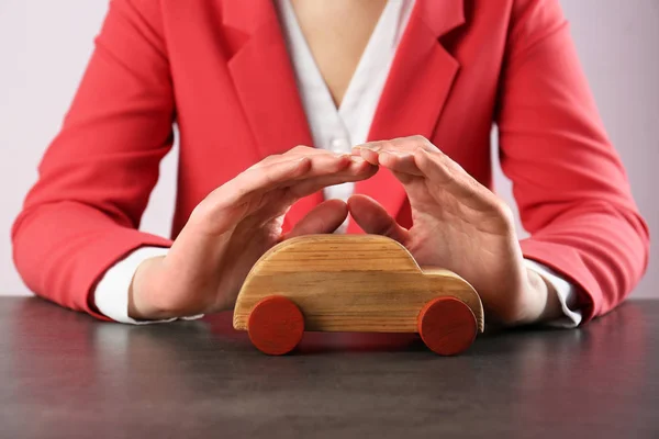 Manos femeninas y coche de juguete de madera —  Fotos de Stock