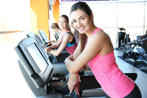 Sportliche junge Frauen stehen im Fitnessstudio auf dem Laufband — Stockfoto