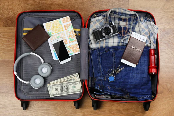 Packed suitcase with travel accessories