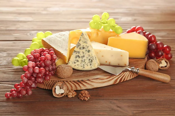 Tavola con varietà di formaggio su sfondo di legno — Foto Stock