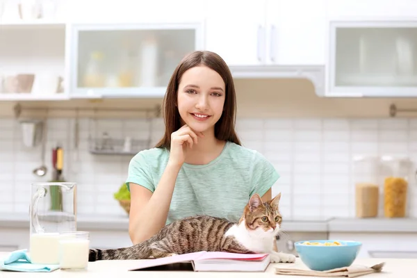 Утро красивой молодой женщины и кота на кухне — стоковое фото