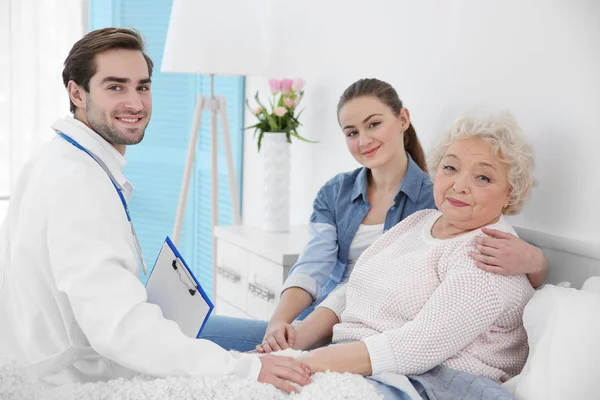 Vacker flicka med mormor gästande läkare — Stockfoto