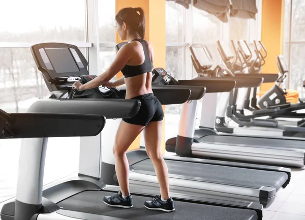 Frau läuft im Fitnessstudio auf Laufband — Stockfoto