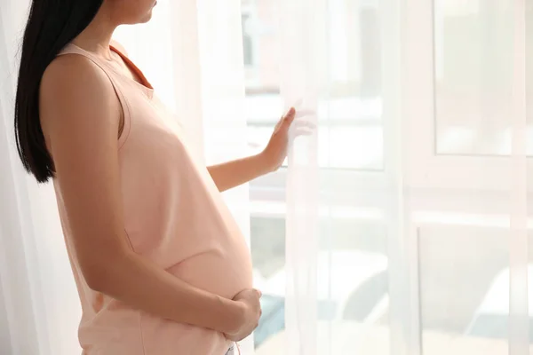 Hermosa mujer embarazada cerca de la ventana en casa — Foto de Stock