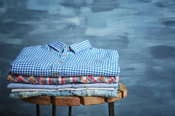 Pile of clothes on wooden stool — Stock Photo, Image